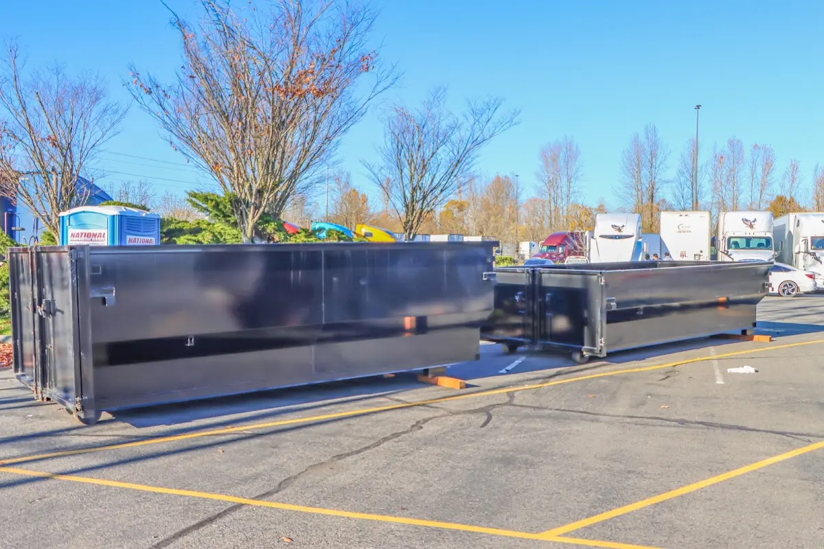 Professional dumpster rental service with roll-off container on residential driveway in Mesa